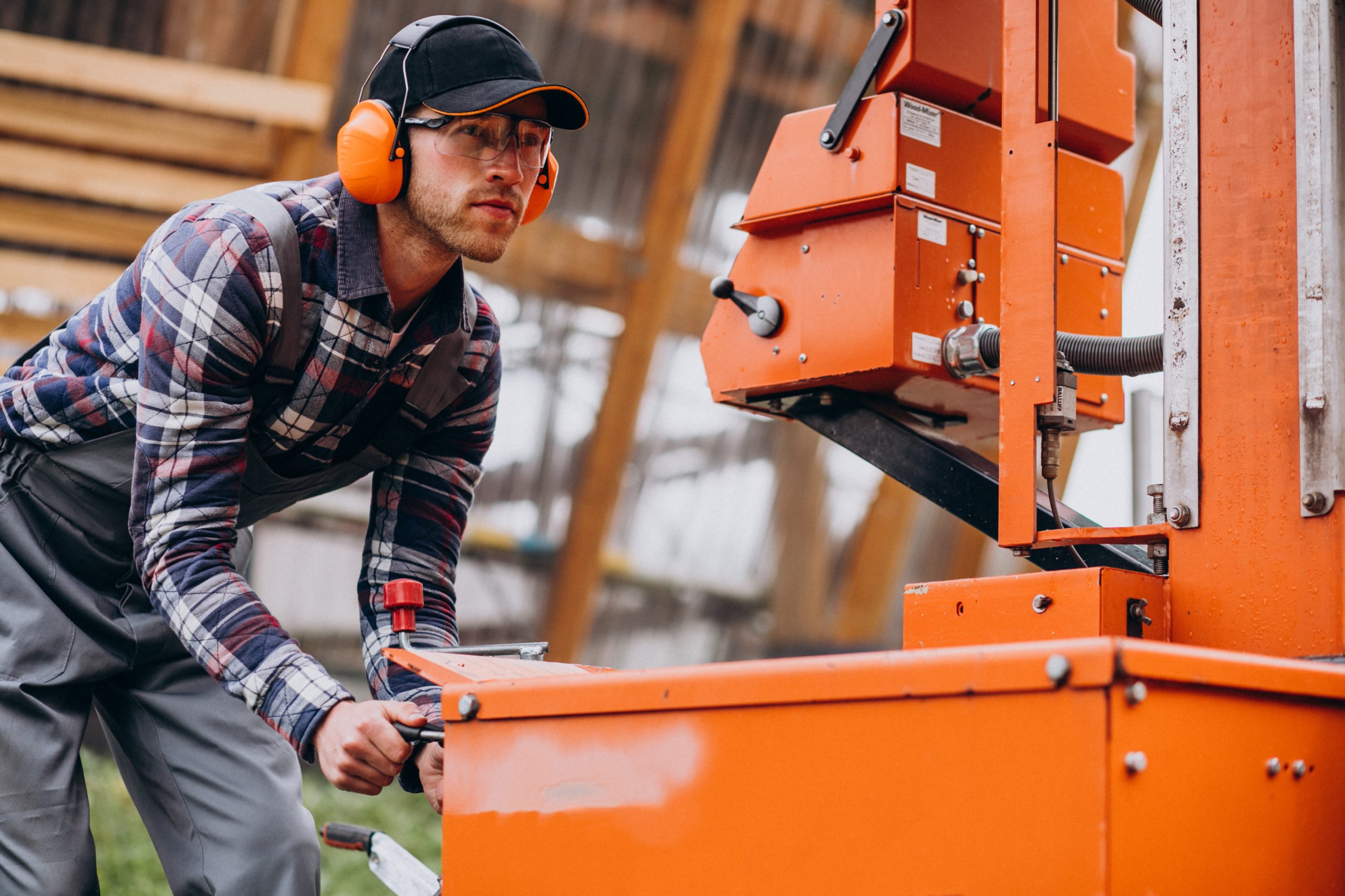 Carpenter working on a sawmill on a wood manufacture
